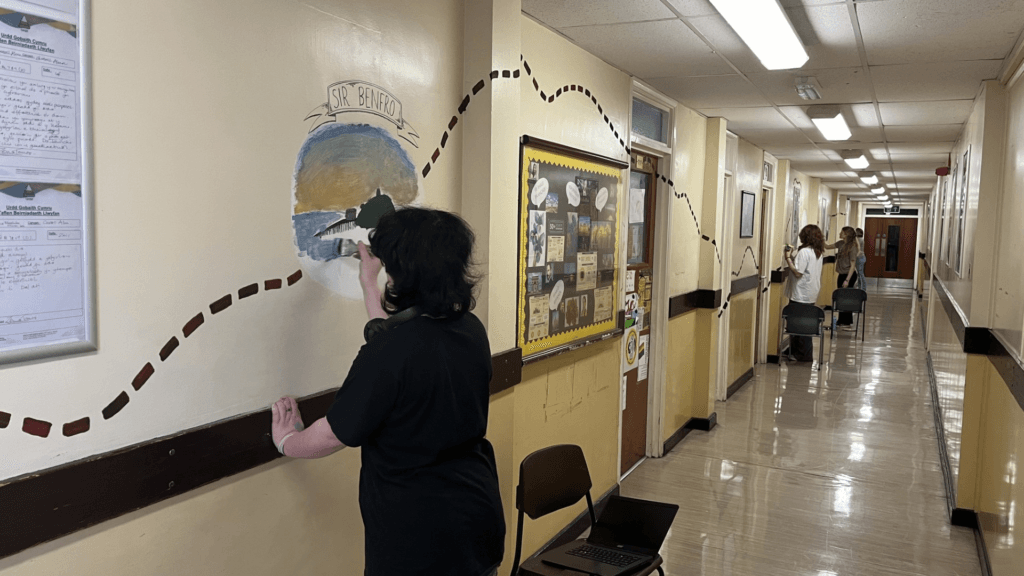 A photo of students working on a mural celebrating Welsh culture on the Modern Languages corridor, circa November 2024