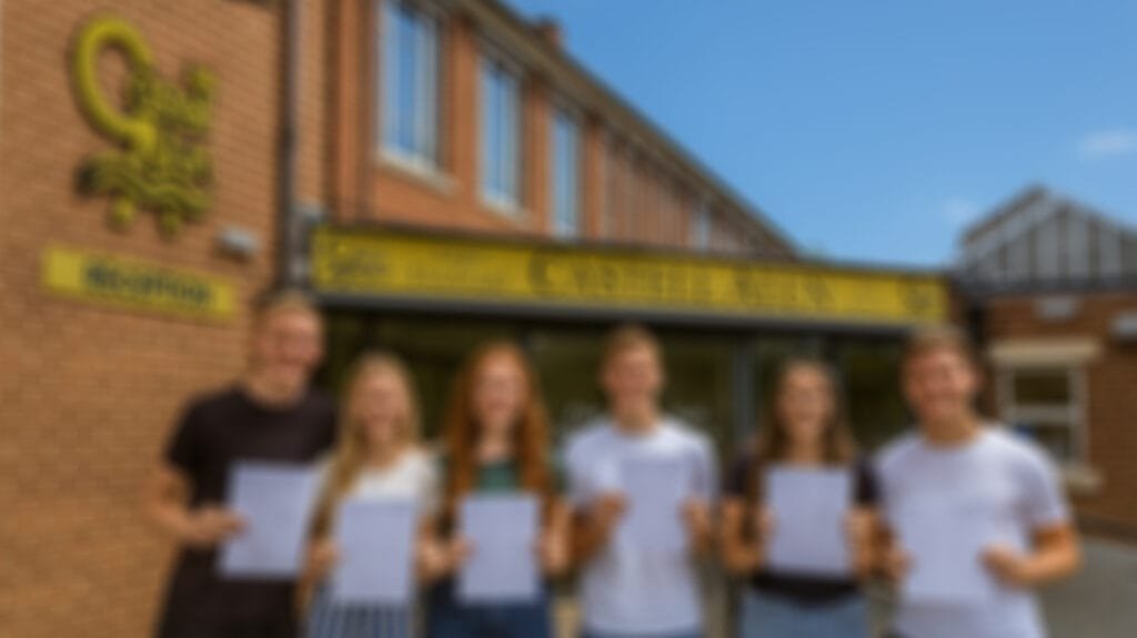 Six students standing outside the entrance to Castell Alun High School, each holding a results sheet while posing for a photograph in front of the school sign and main entrance.