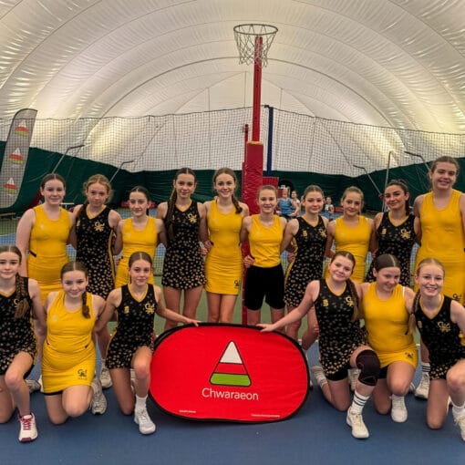 Students posing for a team photo at a netball event, wearing yellow and black kit, circa January 2026