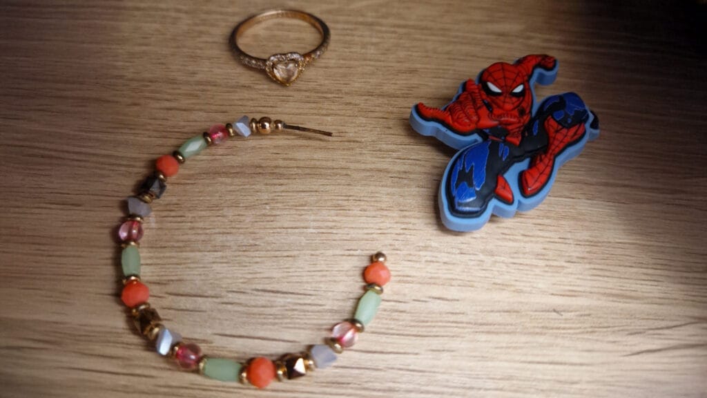 Small unclaimed personal items, including jewellery and a Spiderman keyring, photographed for the school?s lost property system, circa January 2026