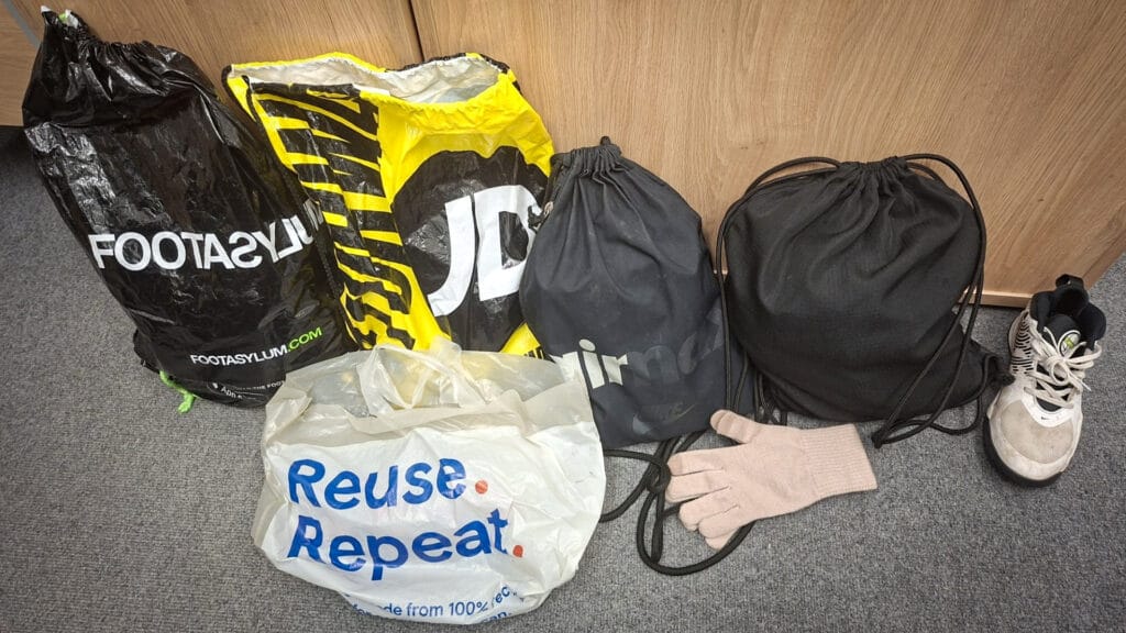 Unclaimed lost property items including bags, a glove and a trainer laid out for collection, circa January 2026