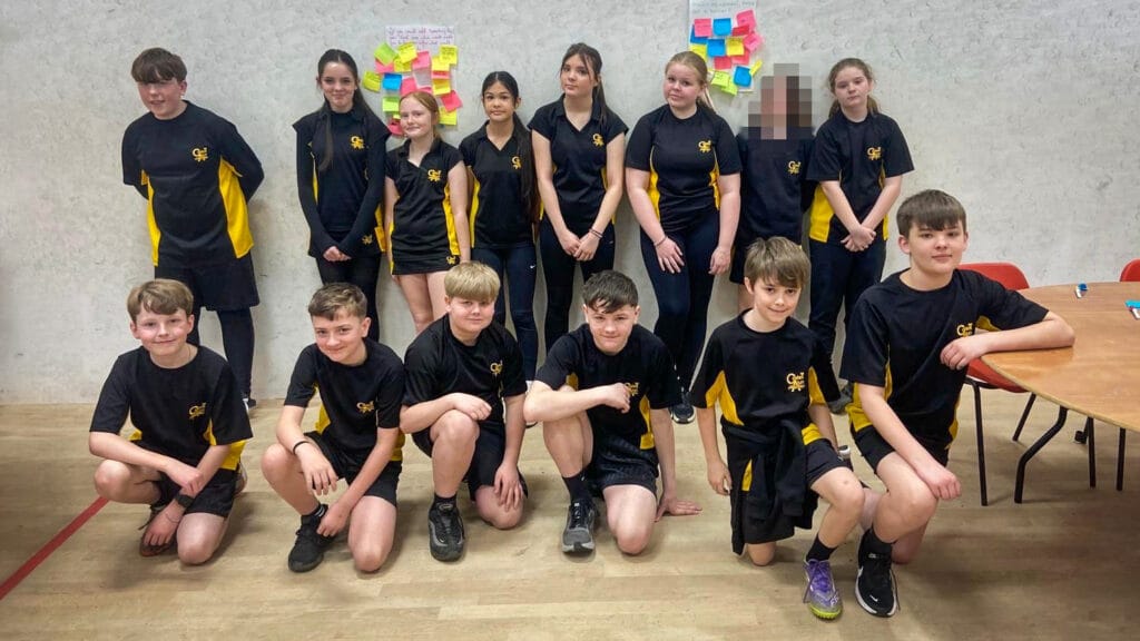 A school team posing indoors in black and yellow kit, circa March, 2026