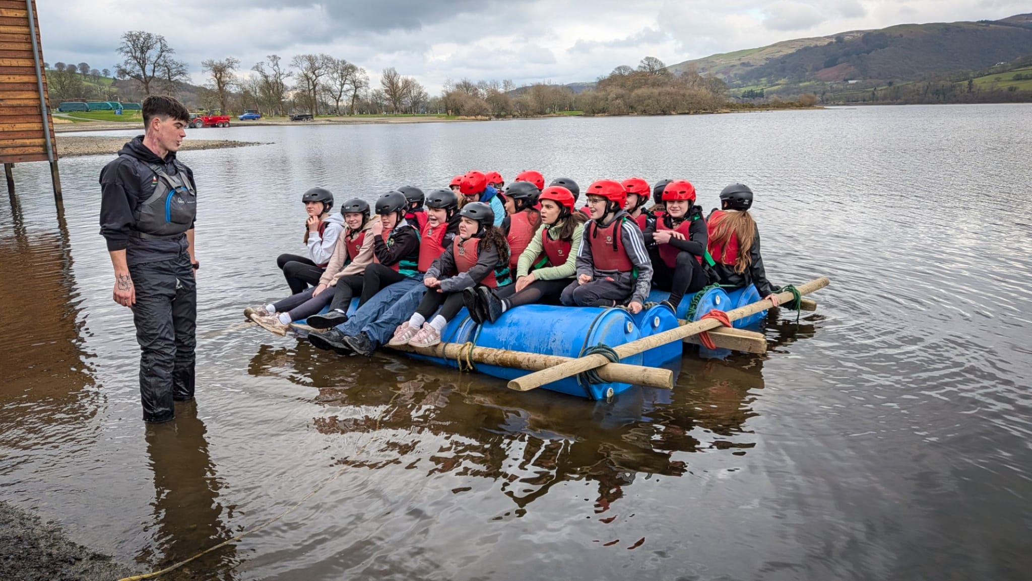 Students sitting on a homemade raft in the lake with an instructor standing nearby, circa March, 2026