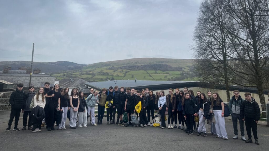 A large group of students posing outdoors at an activity centre with hills in the background, circa March, 2026