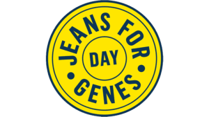 Yellow circular logo with blue text reading “Jeans for Genes Day.” The design features the word “DAY” in the centre, surrounded by “JEANS FOR GENES” in a bold circular layout.
